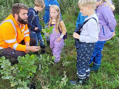 Kai Holzgräfe bestimmt mit den Kindern eine Pflanze anhand ihres Blattes.