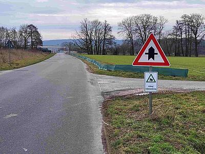 Schild und grüner Krötenzaun entlang der Straße Im Westerbruch.