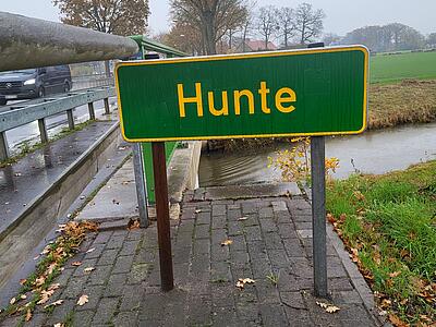 Schild mit Aufschrift Hunte an der stark befahrenen Brücke in Hunteburg