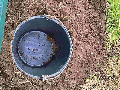 Eimer in der Erde, in den die Kröten fallen werden.