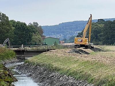 Ein Bagger steht am Ufer der Hunte.